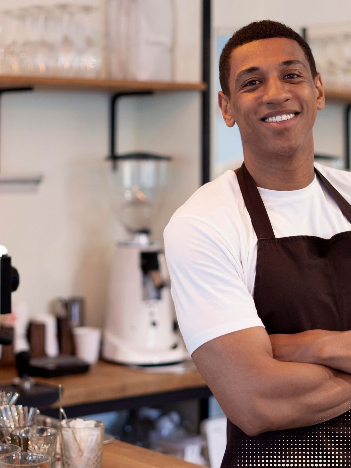 Lojista sorridente atrás do balcão de uma cafeteria